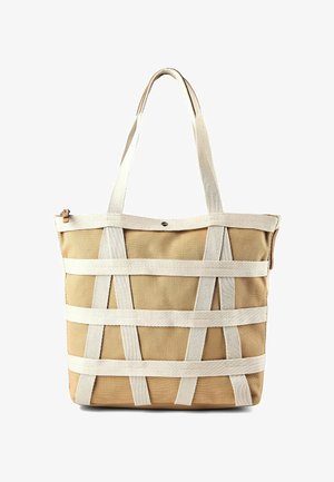 Beige canvas tote bag with cream horizontal and vertical straps, two long handles, and a snap button closure at the top center.