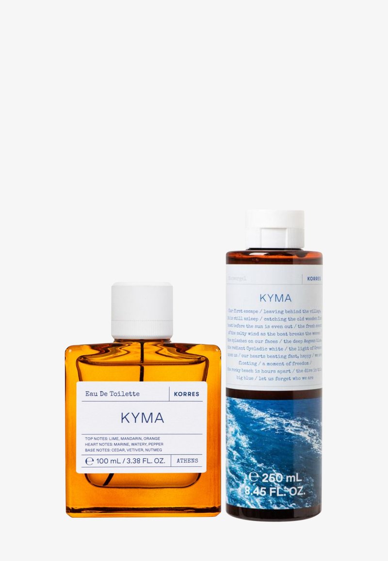 Botella de cristal de color ámbar con tapa blanca etiquetada como "Eau De Toilette KYMA," junto a una botella cilíndrica con acento azul y texto en la etiqueta.