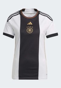 Camisa de fútbol de la selección de Alemania con una combinación de colores en blanco y negro, que presenta acentos dorados, tres franjas en las mangas y un cuello redondo.