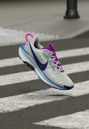 Chaussure de sport à tige en mesh gris clair, logo Swoosh marine, accents violets et une semelle intermédiaire bleue. Caractéristiques : semelle texturée et système de laçage.