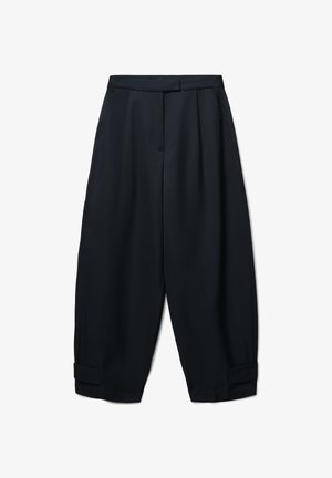 Schwarze, locker sitzende Hose aus glattem Stoff, mit Falten, seitlichen Taschen und umgeschlagenen Säumen. Maßgefertigter Bund ohne sichtbare Verschlüsse.