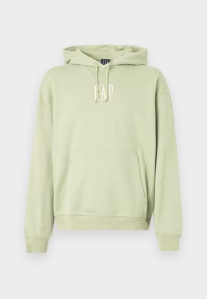 Sweat-shirt à capuche vert clair en tissu doux, comportant une poche frontale et le logo "GAP" en blanc. Poignets et ourlet côtelés.