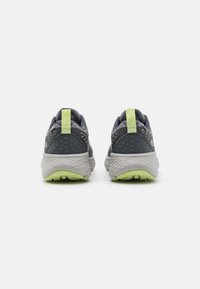 Harmaat urheilukengät, joissa on teksturoitu muotoilu, verkkopäällinen, heijastavia yksityiskohtia sekä vaaleanvihreä ulkopohja ja kantalenkki.