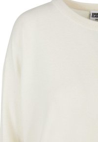 Weißer Strickpullover mit Rundhalsausschnitt und weichem Material. Verfügt über eine lockere Passform und dezente Rippdetails am Kragen und den Bündchen.