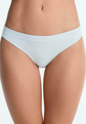 Woman wearing plain white seamless bikini-style underwear, showing torso from waist to mid-thigh against a neutral background.