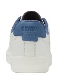 Białe sneakersy z niebieskim skórzanym akcentem na pięcie, teksturowana tkanina i wytłoczone logo K-Swiss z tyłu. Płaska gumowa podeszwa z rowkami.
