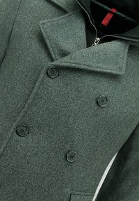 Grijze wolblend peacoat met een dubbele knoopsluiting, zwarte knopen, brede revers en een ritsluiting bij de hals. Glad, gestructureerd stof.