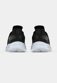 Μαύρα αθλητικά παπούτσια με υφή στο επάνω μέρος, επενδεδυμένο γιακά και λευκή λαστιχένια σόλα με χαρακτηριστικά πέλματα και ενισχυμένη φτέρνα.