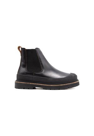 Botte Chelsea en cuir noir avec panneau latéral élastique, semelle en caoutchouc épaisse, languette de tirage au talon marron, et semelle texturée pour une bonne adhérence.