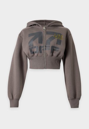 Sweat à capuche court marron avec fermeture éclair frontale, manches longues, poignets côtelés, et texte graphique noir et jaune sur la poitrine.
