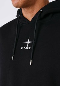 Felpa nera con cappuccio, dotata di cordino con punte metalliche, logo frontale "PXF" in bianco e tessuto morbido e strutturato.