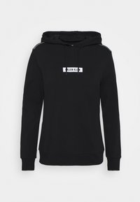 Sudadera con capucha negra hecha de tela suave. Presenta una etiqueta con logo en el frente, mangas largas y un cordón en el cuello. Diseño sencillo.