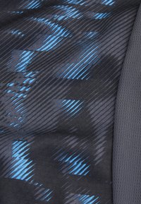 Zwarte textuurstof met blauwe diagonale strepen en patronen, aangevuld met een contrasterend grijs gedeelte aan de rechterkant.