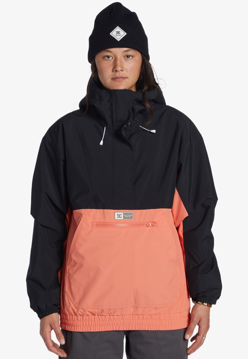 Chaqueta impermeable negra y coral con capucha, puños elásticos, bolsillo delantero con cremallera y parche del logo de DC en el pecho.