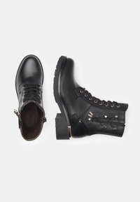 Black leather ankle boots with a round toe, gold eyelets, and decorative side lacing. Thick rubber sole for traction.