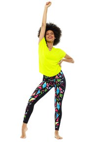 Neon yellow loose-fitting top paired with black leggings featuring a colorful geometric pattern in pink, blue, and green.