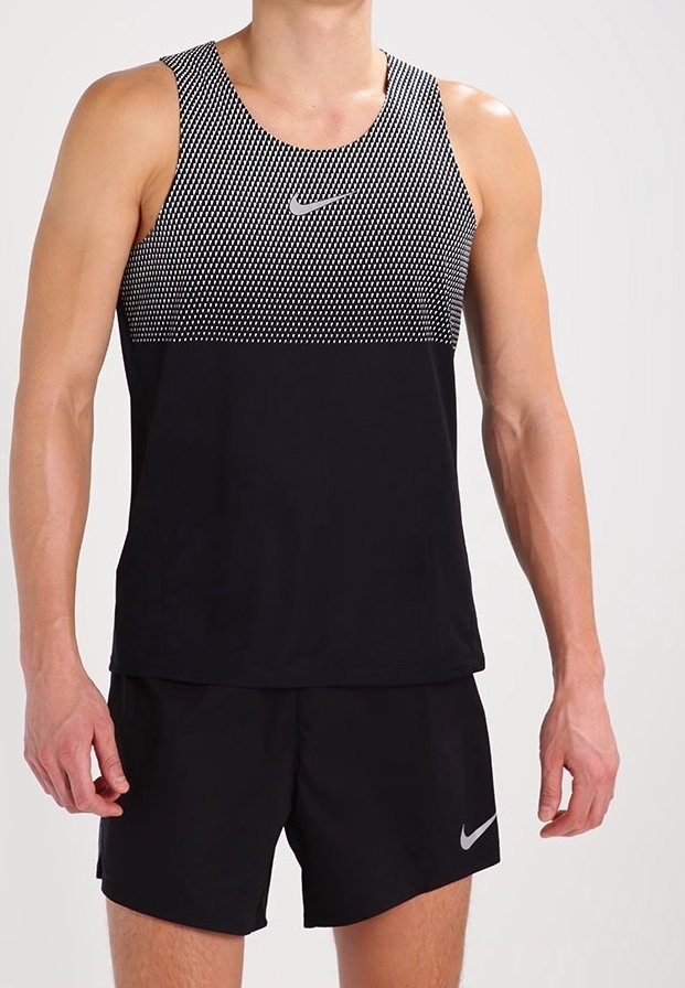 Débardeur sportif noir avec un motif à pois sur la partie supérieure et une section inférieure noire unie, arborant un petit logo Nike argenté.