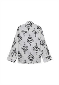 Camicia a maniche lunghe bianco e nero con colletto, caratterizzata da disegni intricati e polsini abbottonati, realizzata in tessuto leggero.