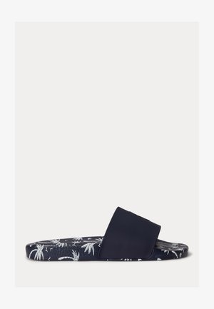 Granatowy klapek na płaskiej podeszwie z szerokim paskiem i wzorem białych palm oraz tropikalnych liści na podeszwie.