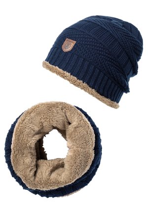 Bonnet d'hiver en maille bleu marine et tour de cou assorti avec une doublure en polaire beige et un petit patch en cuir sur le bonnet.