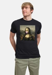 Camiseta negra de manga corta con un gráfico de la Mona Lisa con una burbuja de chicle rosa. Material de algodón, corte relajado.