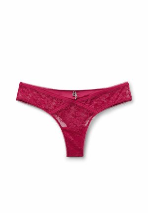 Czerwone damskie stringi z koronki z kwiatowym wzorem, przezroczystą tkaniną, falistymi krawędziami i małym srebrnym charmsiem na środku pasa.