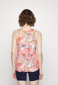 Top de alças floral com tons de rosa, laranja e cinza; tecido leve; design sem mangas; barra ligeiramente curvada; combinado com calções azul-marinho.