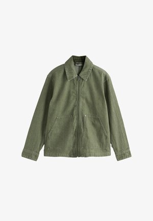 Olīvu zaļa korduroja jaka ar apkakli, priekšējo rāvējslēdzēju un divām lielām slīpi izvietotām kabatām. Raksturīga vertikāla ribota tekstūra un gari piedurkņi.