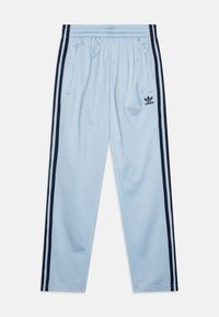 Pantaloni della tuta azzurri con una texture morbida, strisce laterali nere e tasche con cerniera. Presentano un piccolo logo Adidas nero sul retro.
