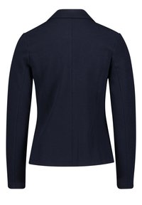 Náměsíčně modrá bunda se strukturovaným designem, dlouhými rukávy, límcem a ribbovanou texturou. Švy probíhají vertikálně dolů po zádech.