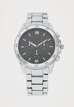 Montre-bracelet en métal argenté avec un cadran noir, des index horaires blancs et des sous-cadrans chronographiques. Elle est dotée d'un bracelet à maillons en acier inoxydable.