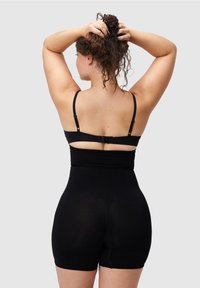 Czarny body z regulowanymi ramiączkami i zapięciem z tyłu. Charakteryzuje się bezszwową konstrukcją, elastycznym materiałem i długością do połowy uda.
