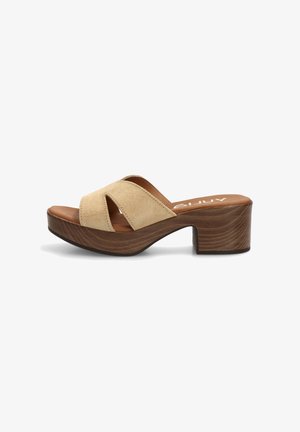 Sandalia mule de ante beige con puntera abierta, plataforma de madera y tacón ancho, diseño sin cierre y tiras superiores recortadas.
