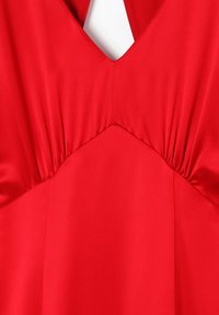 Robe en satin rouge avec un décolleté en V profond, des fronces au niveau de la poitrine et une texture lisse. Coupe ajustée avec un ourlet évasé.