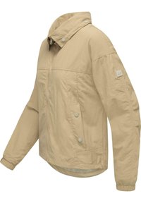 Ljust beige jacka med dragkedja fram, tryckknappar, hög krage, elastiska manschetter och en avslappnad passform. Mjuk, texturerad tyg.