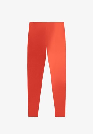 Pantaloni aderenti arancione brillante con vita alta e cuciture sottili delle tasche anteriori, esposti su uno sfondo bianco.