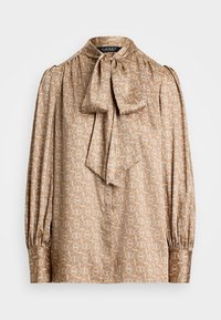 Blouse in light beige fabric with geometric pattern in cream and gold. Features a bow tie collar and gathered long sleeves.