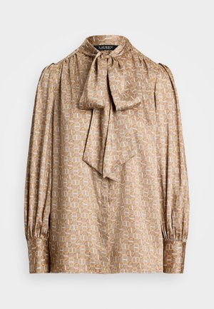 Blusa in tessuto beige chiaro con motivo geometrico in crema e oro. Presenta un colletto a fiocco e maniche lunghe arricciate.