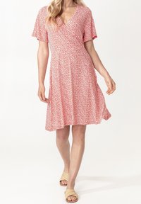 Punainen kukkakuosiset kietaisumekko, jossa on V-neck, lyhyet hihat, vyötärölle kiristetty malli ja A-linjainen hame, valmistettu kevyestä kankaasta. Kihara rakenne ohuilla kuvioilla.