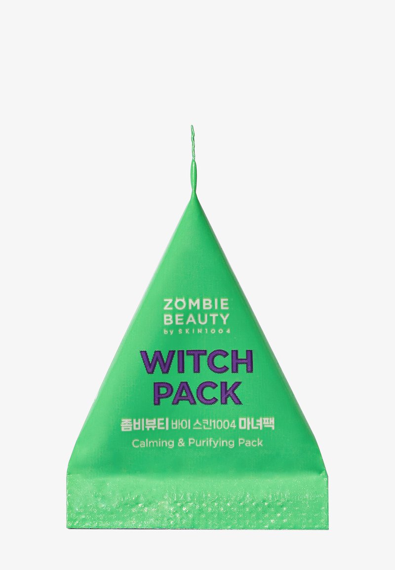 Paquet triangulaire vert étiqueté "WITCH PACK" avec un texte violet audacieux, contenant un masque facial apaisant et purifiant.