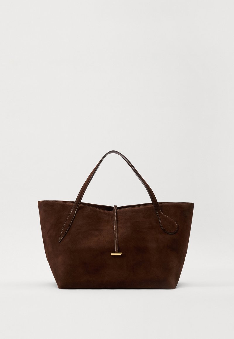 Καφέ σουέτ τσάντα tote με δύο χερούλια, λεία υφή, επιμηκυμένη μορφή και χρυσή λεπτομέρεια στη μέση.