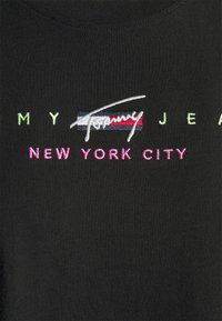 Black cotton T-shirt featuring multicolored embroidered text: "MY JEAN" in green, "TOMMY" in white, and "NEW YORK CITY" in pink.