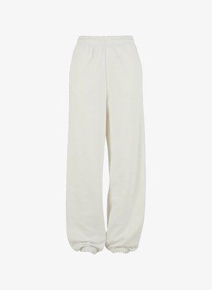 Krémové tepláky s elastickým pásom a elastickými manžetami, uvoľnený strih a mäkká textúra.