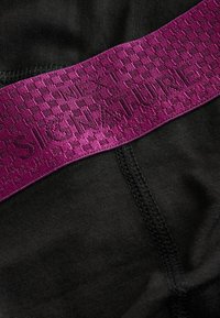 Material textil de culoare neagră cu un brâu elastic violet, prezentând un model texturat și text embosat "SIGNATURE NEXT". Textură netedă, cusături minime.