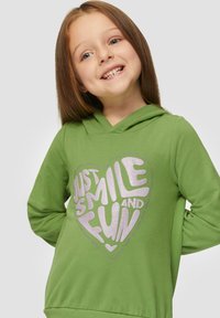 Groene hoodie met een hartontwerp en de tekst "GEWOON LACHEN EN VERMaken" in zilveren glitter. Zachte stof met een relaxte pasvorm en een verstelbare capuchon.