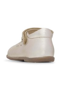 Zapato de cuero metálico rosa con punta redondeada. Presenta una correa de Velcro y una suela texturizada con un sutil patrón decorativo en la parte superior.