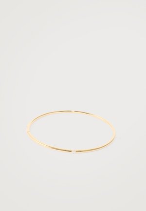 Guldbanglearmbånd med et tyndt, cirkulært design, der har en lille, indlagt klar ædelsten fortil. Glat, poleret overflade.
