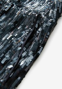 Schwarzer Paillettenstoff mit glänzenden, runden Pailletten in verschiedenen Farbtönen, die eine strukturierte, schimmernde Oberfläche erzeugen. Glattes, darunterliegendes Material.