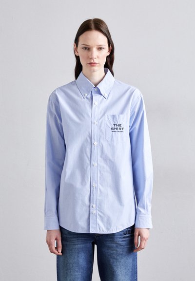 Lysblå stribede button-up skjorte med en brystlomme med trykt tekst. Lange ærmer og en klassisk kravedesign.
