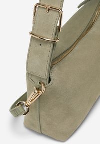 Wildleder-Handtasche in gedämpftem Grün mit einer goldfarbenen Metallschnalle und -beschlägen. Verfügt über einen Reißverschluss und einen abnehmbaren Schultergurt.